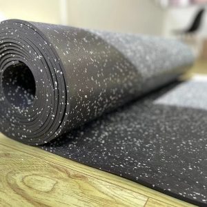 Gym Accessories- (300*300)- Close view of the Black Flooring Mat (7000MM*1000MM*5MM) with multi-colour particles visible along with few gaps in the rolled layers