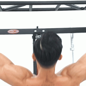 Muscular man performing pull-ups on the light commercial squat full rack