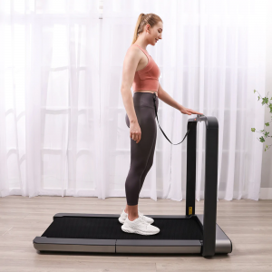 Cardio Equipment- Vertical view of Woman changing settings of the WalkingPad x21 treadmill using the digital display before exercise