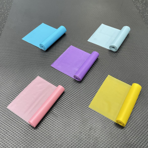 Weight Lifting Accessories- 5 partially unwound Flat Resistance Bands of colours Blue, Grey, Purple, Pink placed on a gym floor in an "X" shape