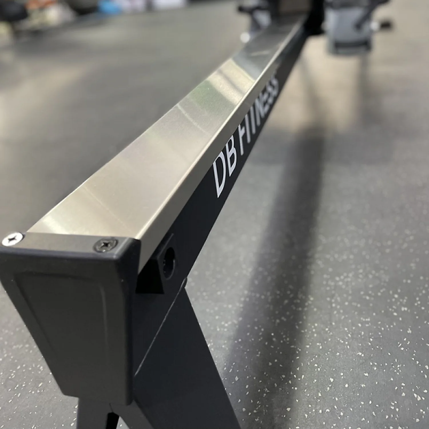 DB Fitness air rower aluminium rail close-up showing the DB Fitness branding and frame construction
