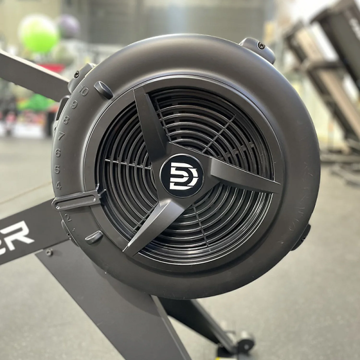 DB Fitness air rower flywheel close-up showing the fan resistance housing and DB logo